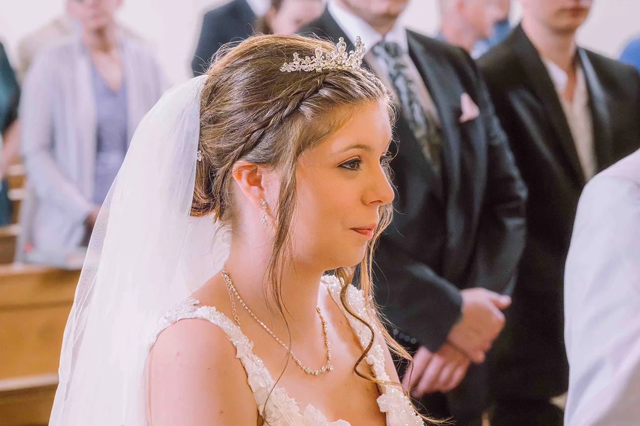 Hochzeitsreportage, glückliche Braut bei der kirchlichen Trauung, Seitenansicht