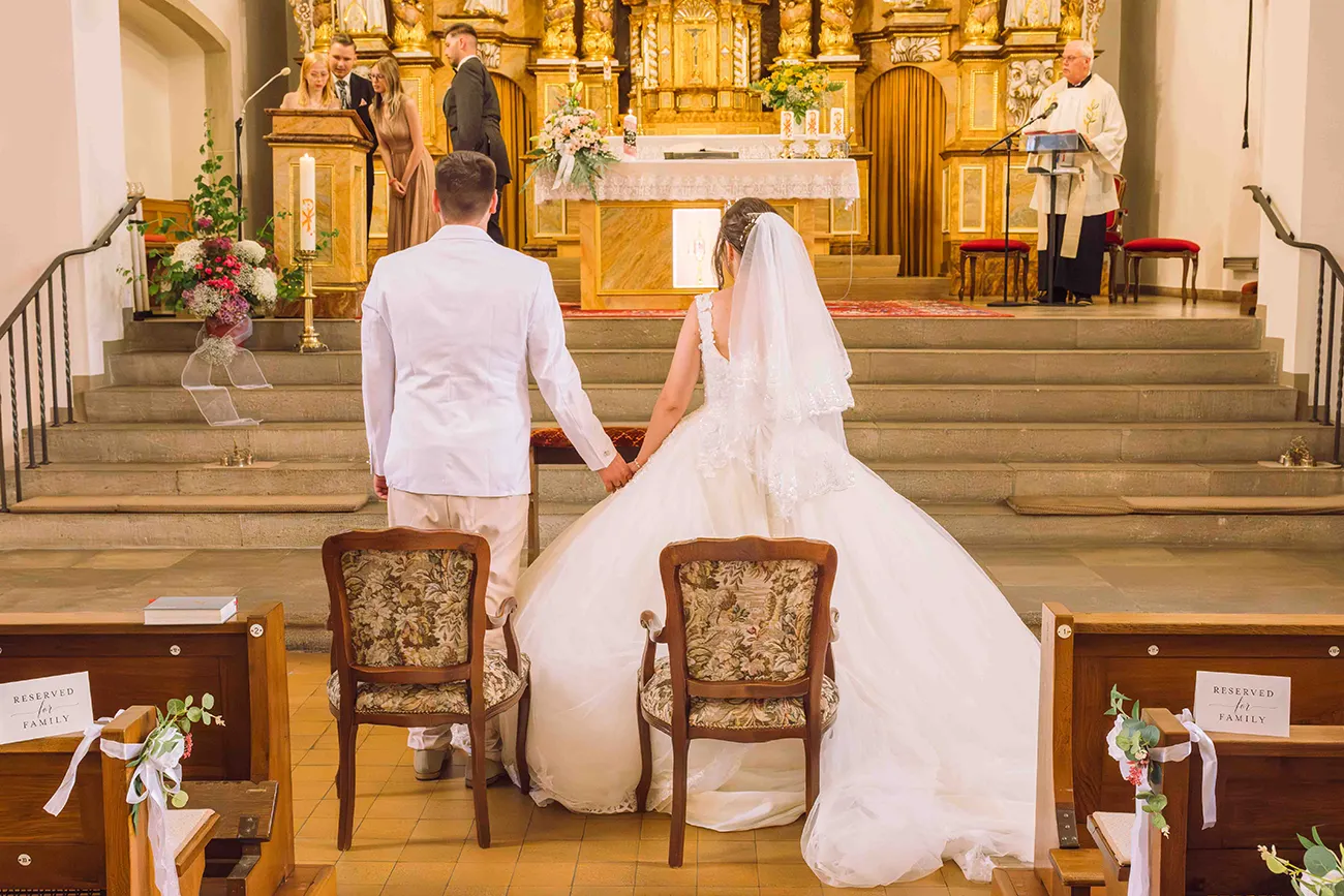 Hochzeitsreportage, das Brautpaar vor dem Altar, von hinten fotografiert