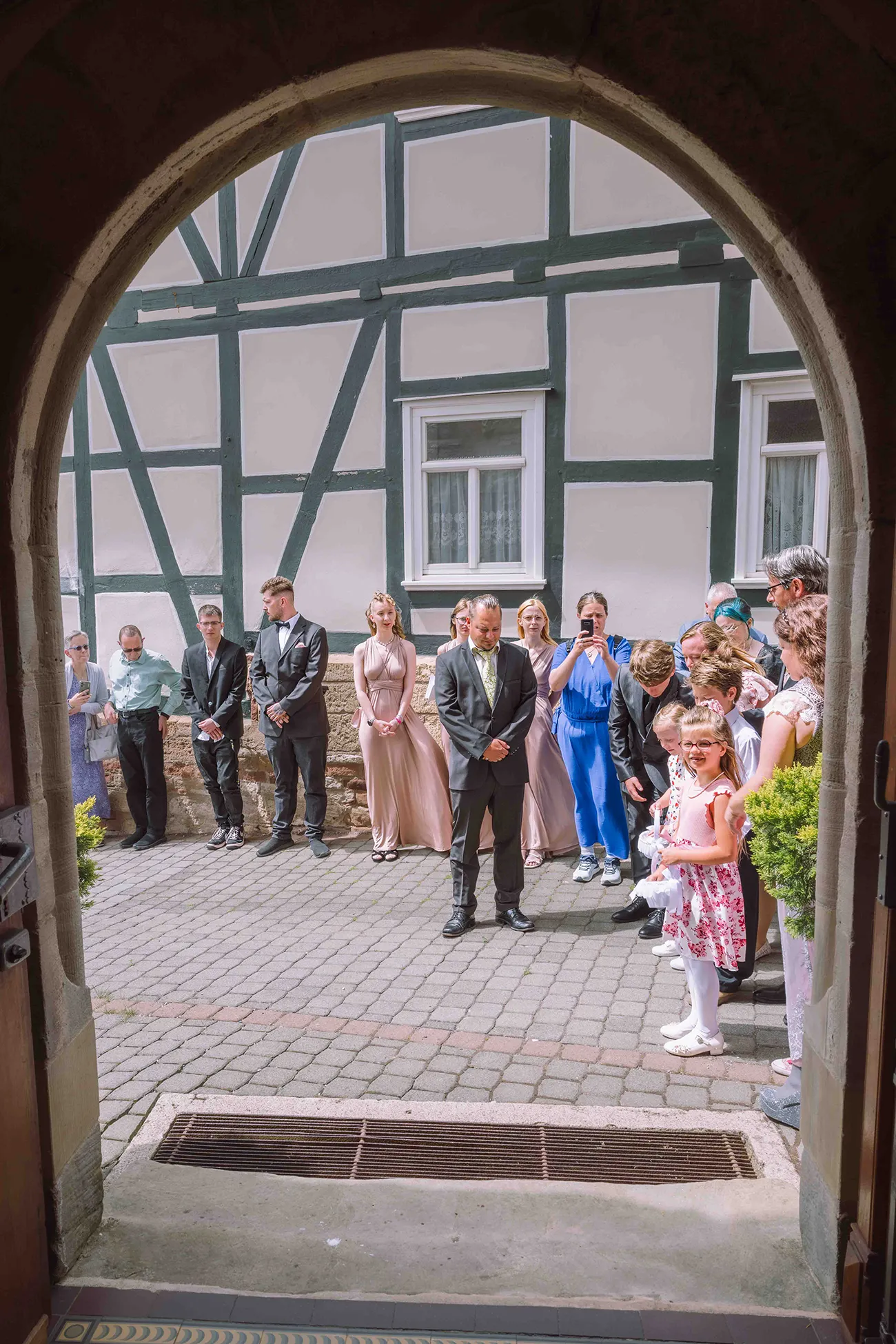 Ein Blick aus der Kirchentür auf die Hochzeitsgratulanten