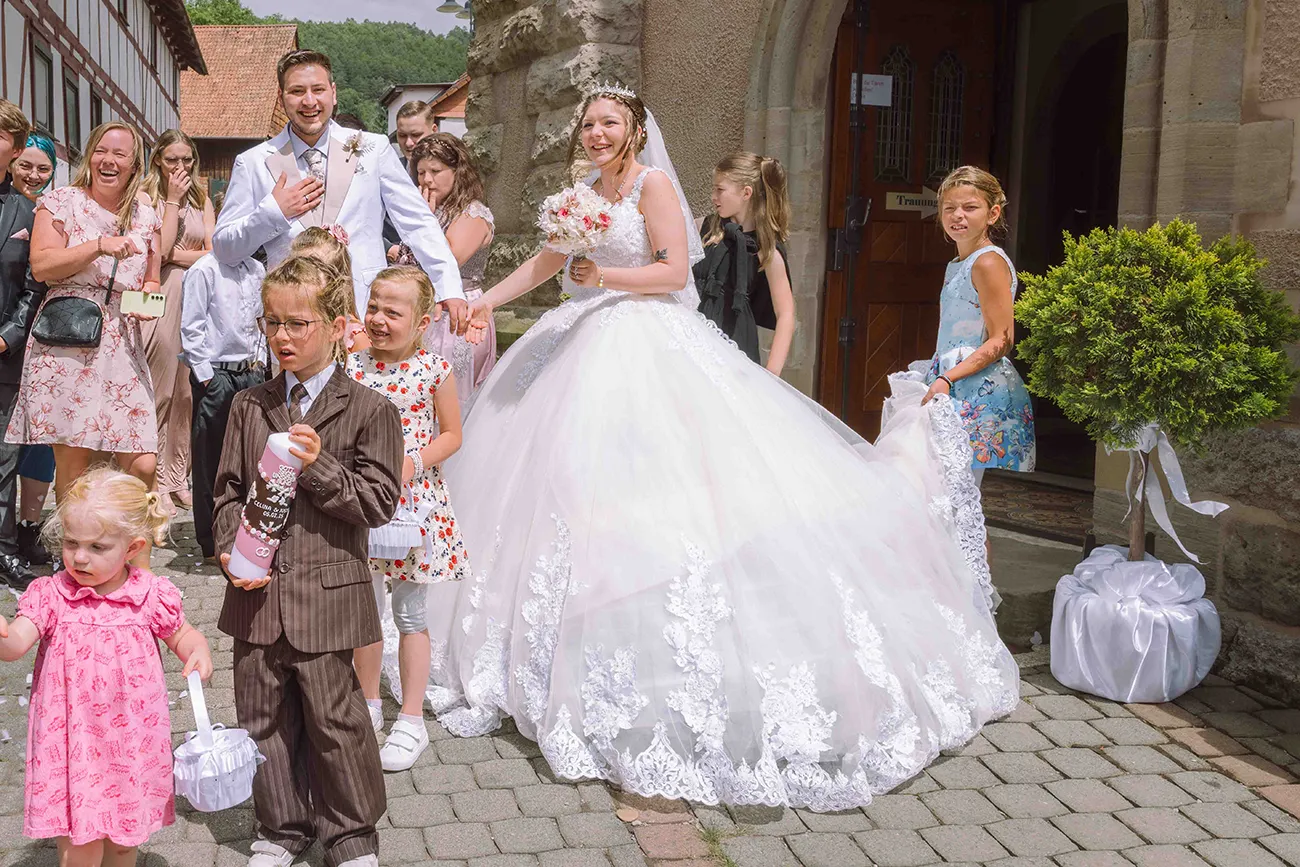 Das Brautpaar kommt glücklich aus der Kirche nach der Trauung