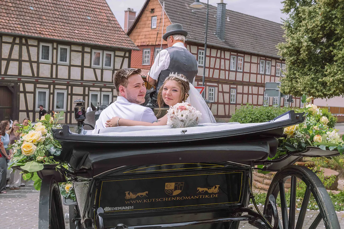 Ein letzter Blick zurück während das Brautpaar mit der Kutsche davon fährt