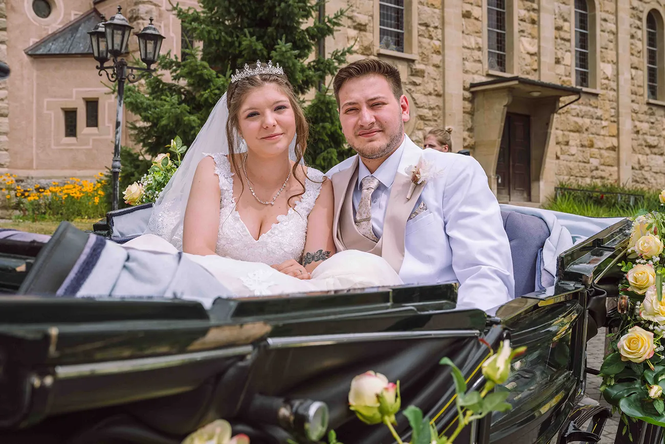 Das Brautpaar sitzt gemeinsam in der Kutsche