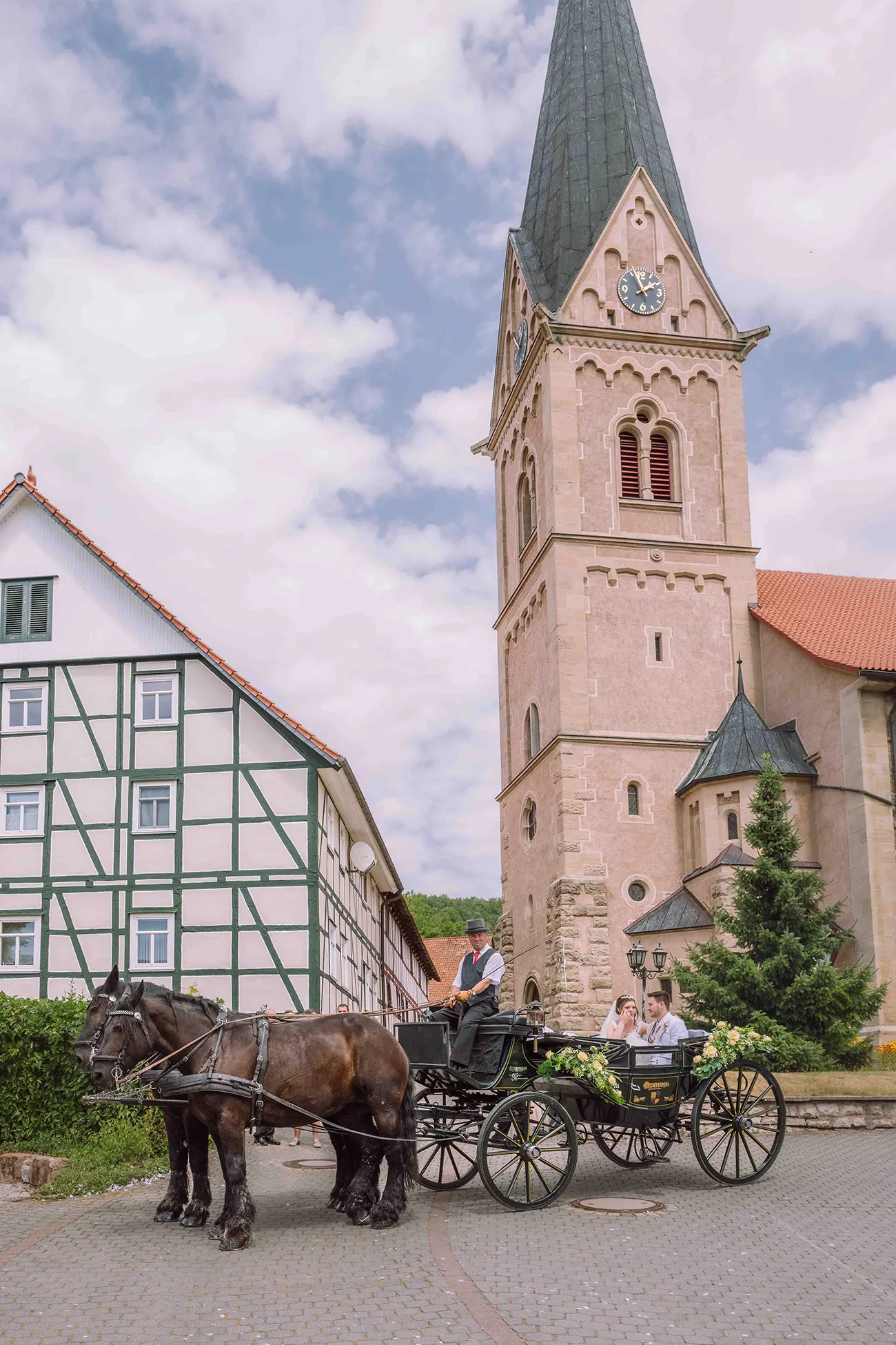 Hochzeitsreportage in Thüringen, Brautpaar sitzt in Kutsche vor der Kirche