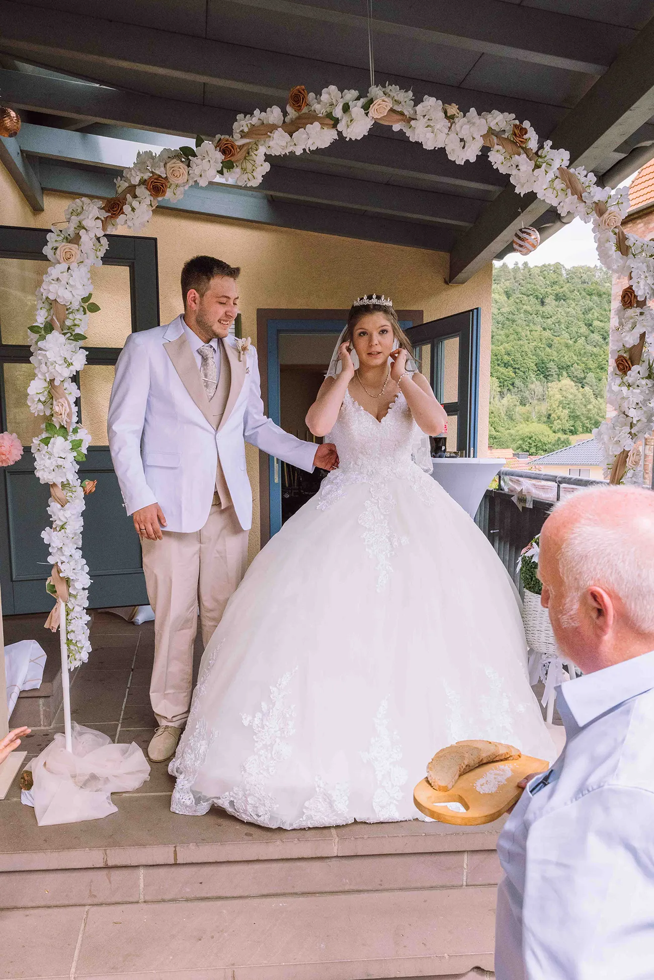 Hochzeitsreportage, das Brautpaar unter dem Rosenbogen