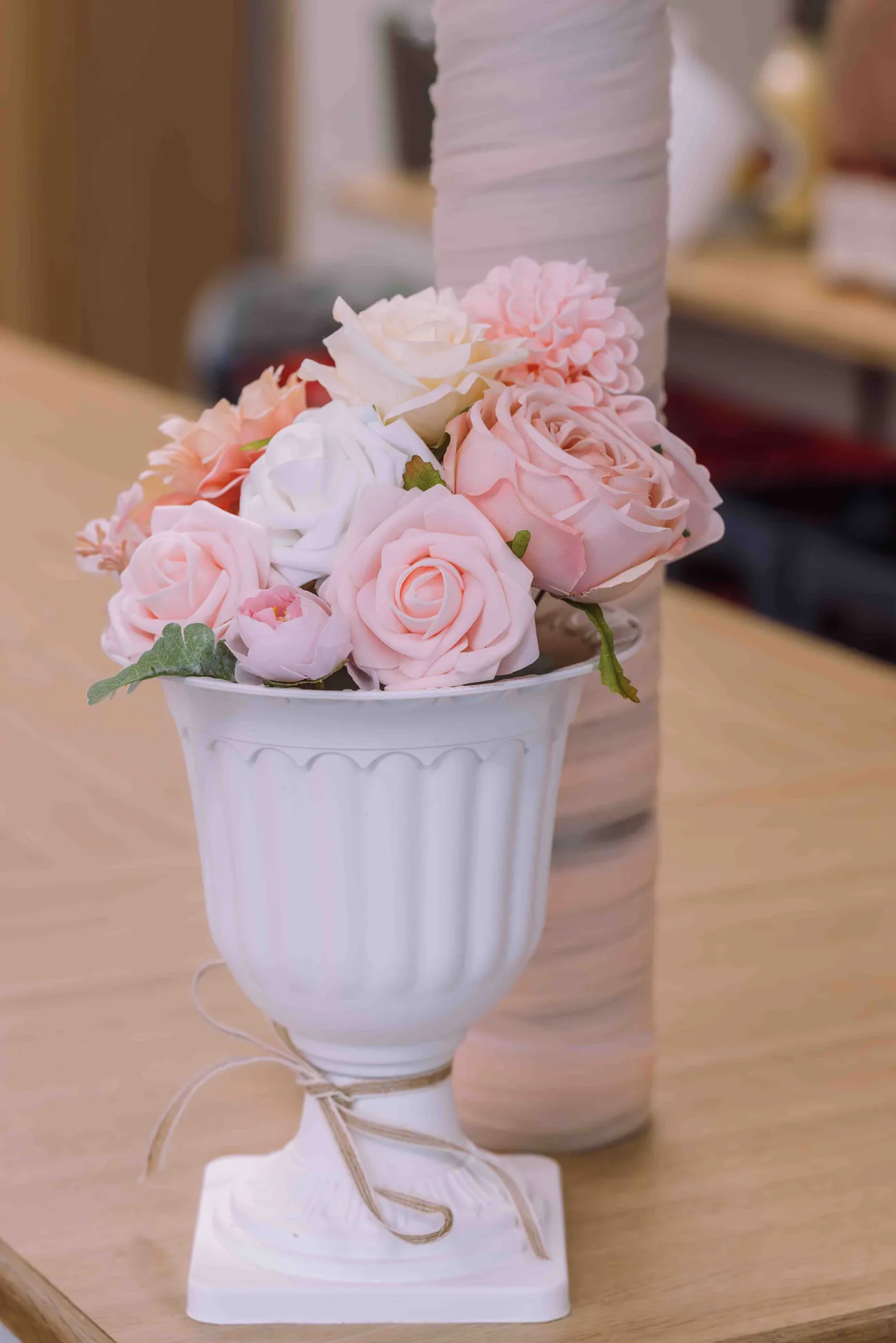 Hochzeitsreportage, Blumengesteck mit weissen und pastellfarbenen Rosen auf der Hochzeit