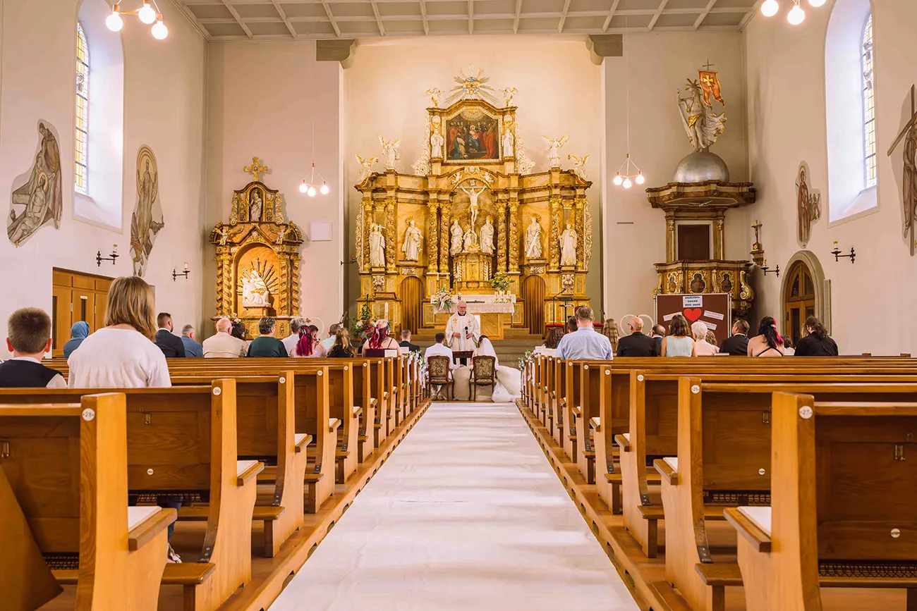 Brautpaar bei der kirchlichen Hochzeit durch den Kirchentag von hinten Fotografiert