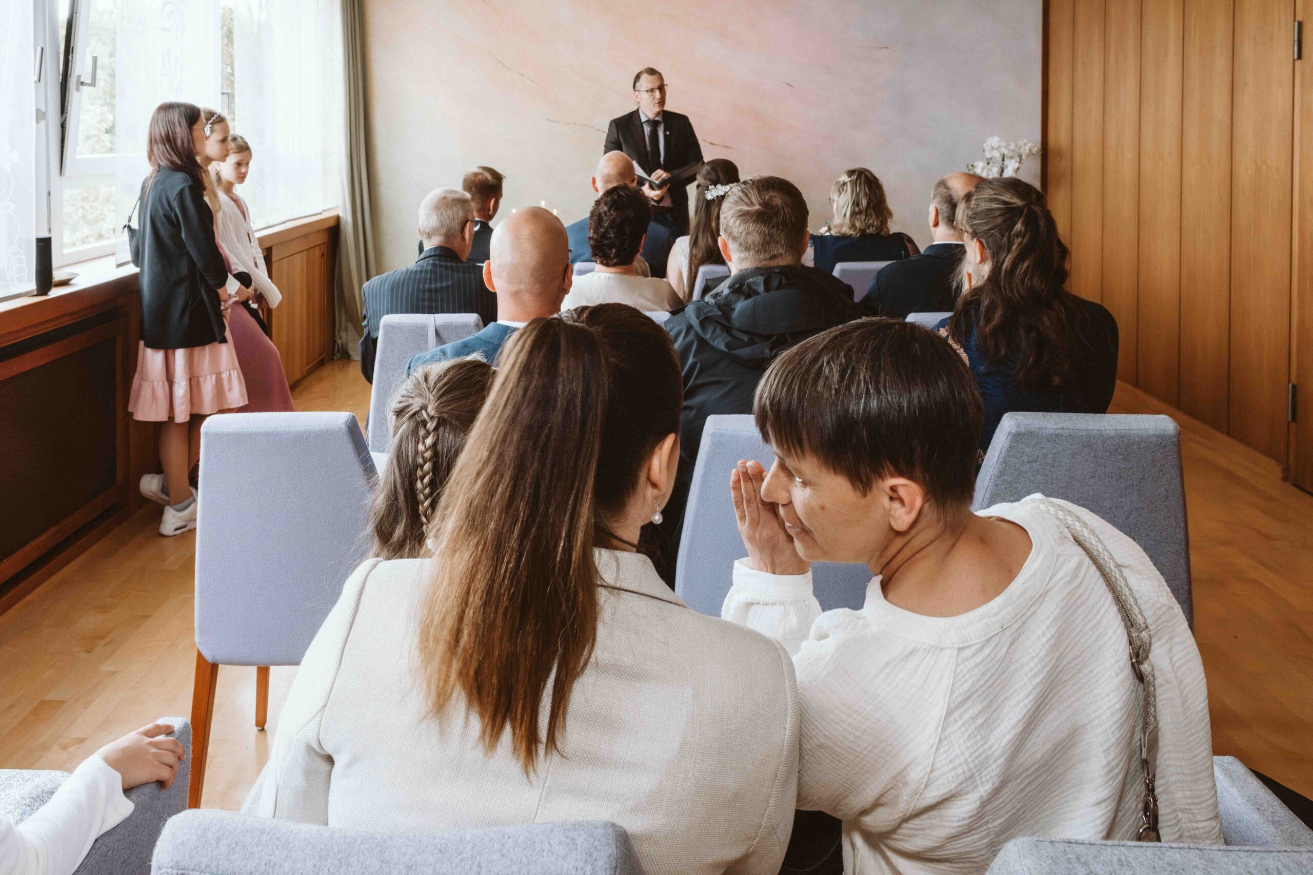 Gäste tuscheln bei der Trauung im Standesamt