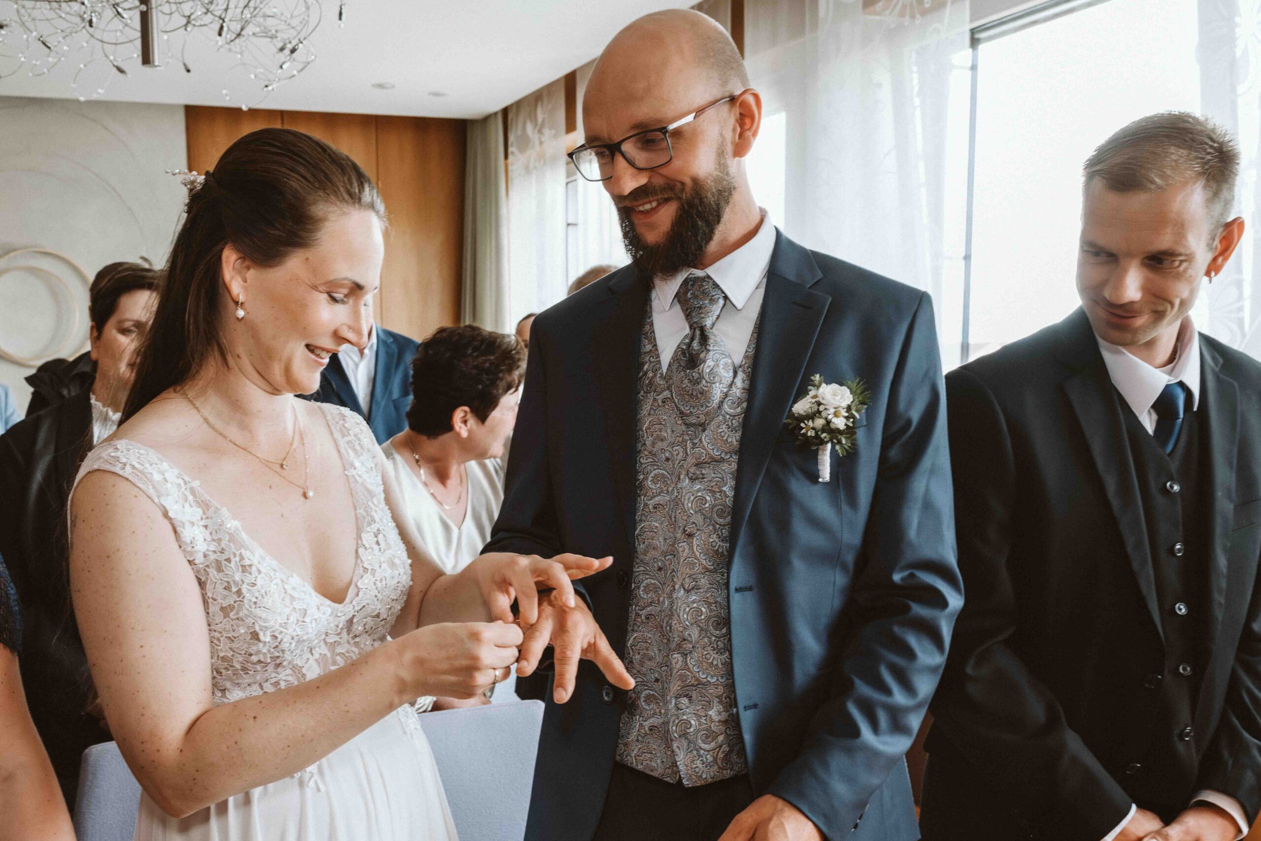 Hochzeitsfotografie. Die Braut steckt dem Bräutigam den Ehering an den Finger