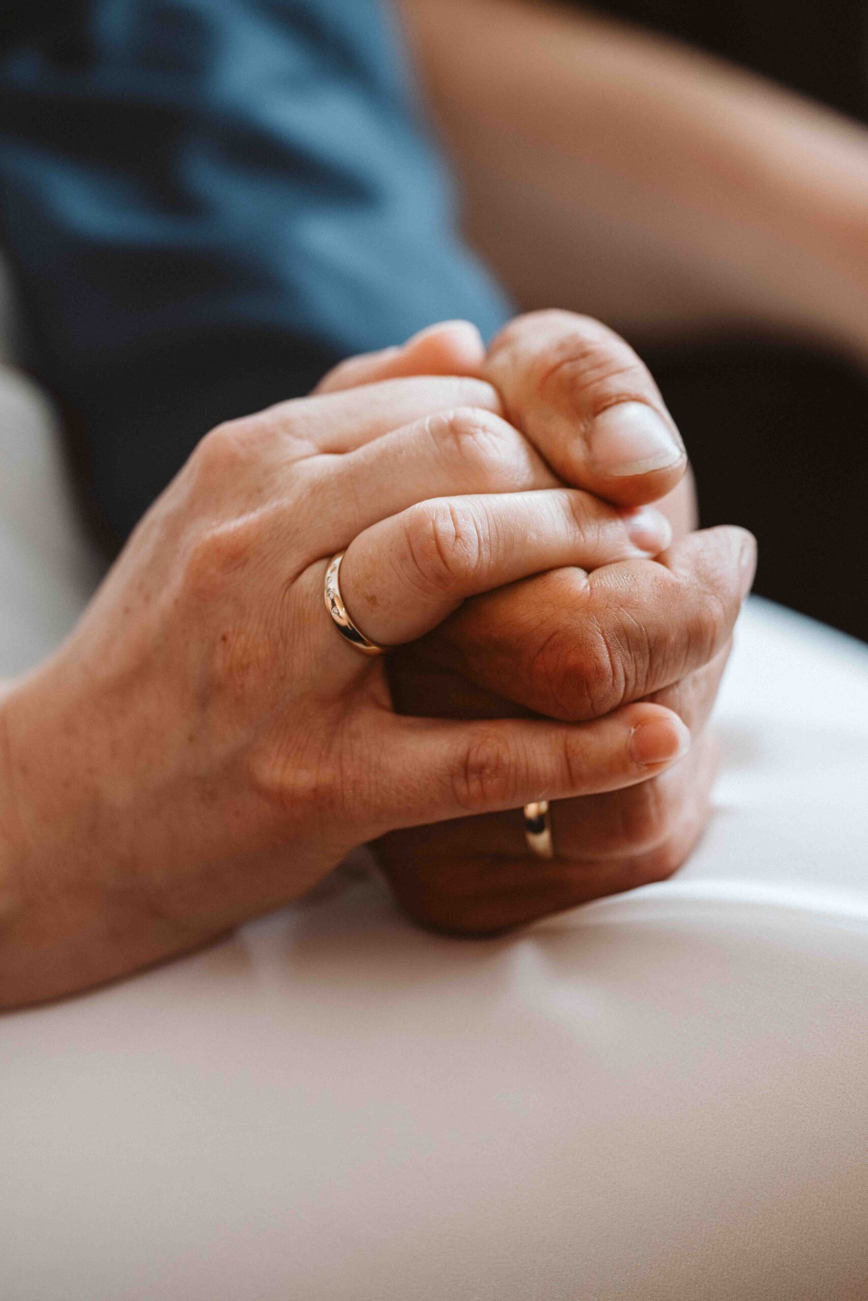 Hochzeitsreportage, frisch Vermählt auf dem Standesamt. Hände von Braut und Bräutigam mit Eheringen.