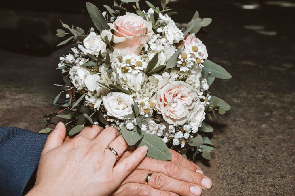 Brautstrauß mit den Händen des Brautpaares