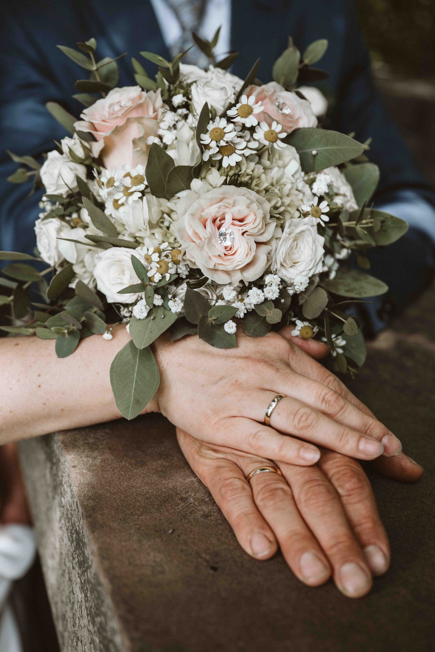 Brautstrauß mit den Händen des Brautpaares
