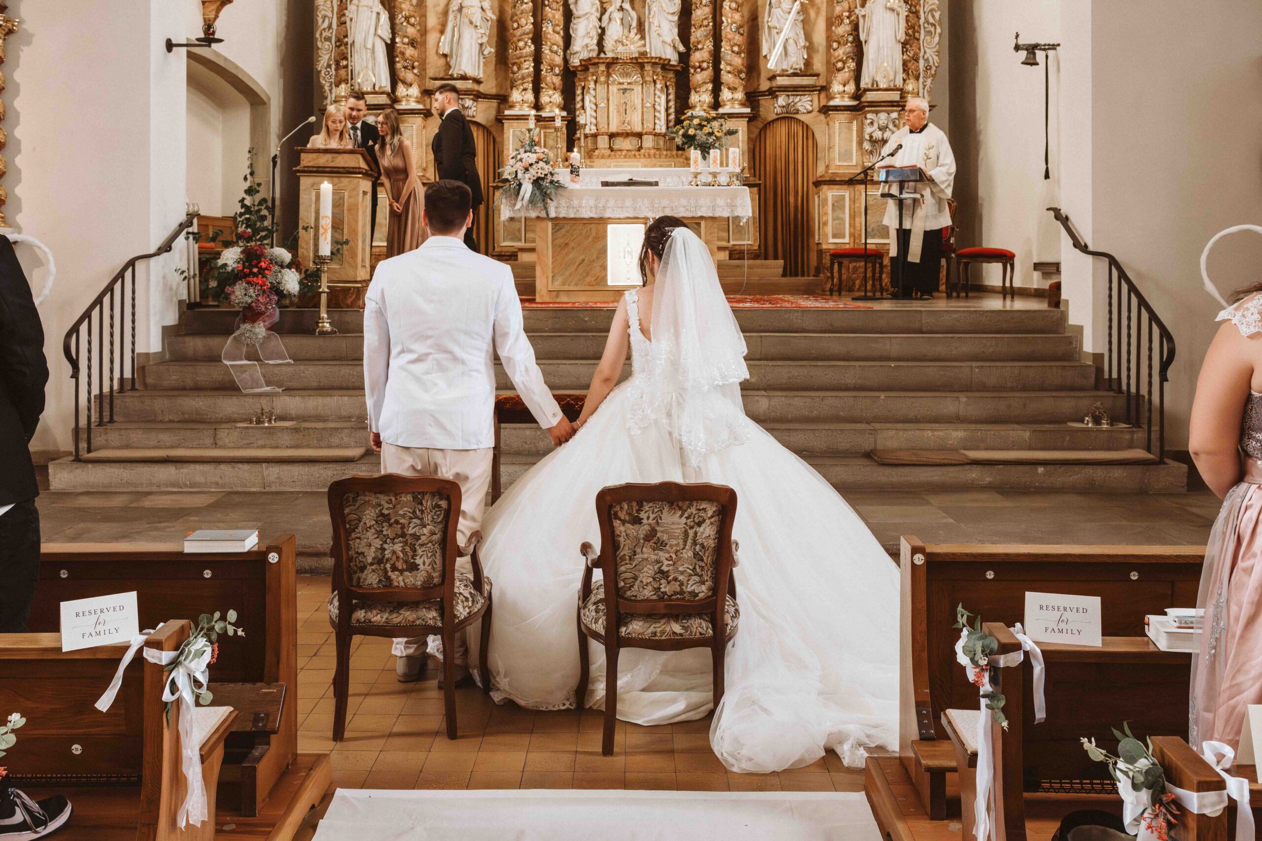 Hochzeitsreportage, das Brautpaar vor dem Altar, von hinten fotografiert