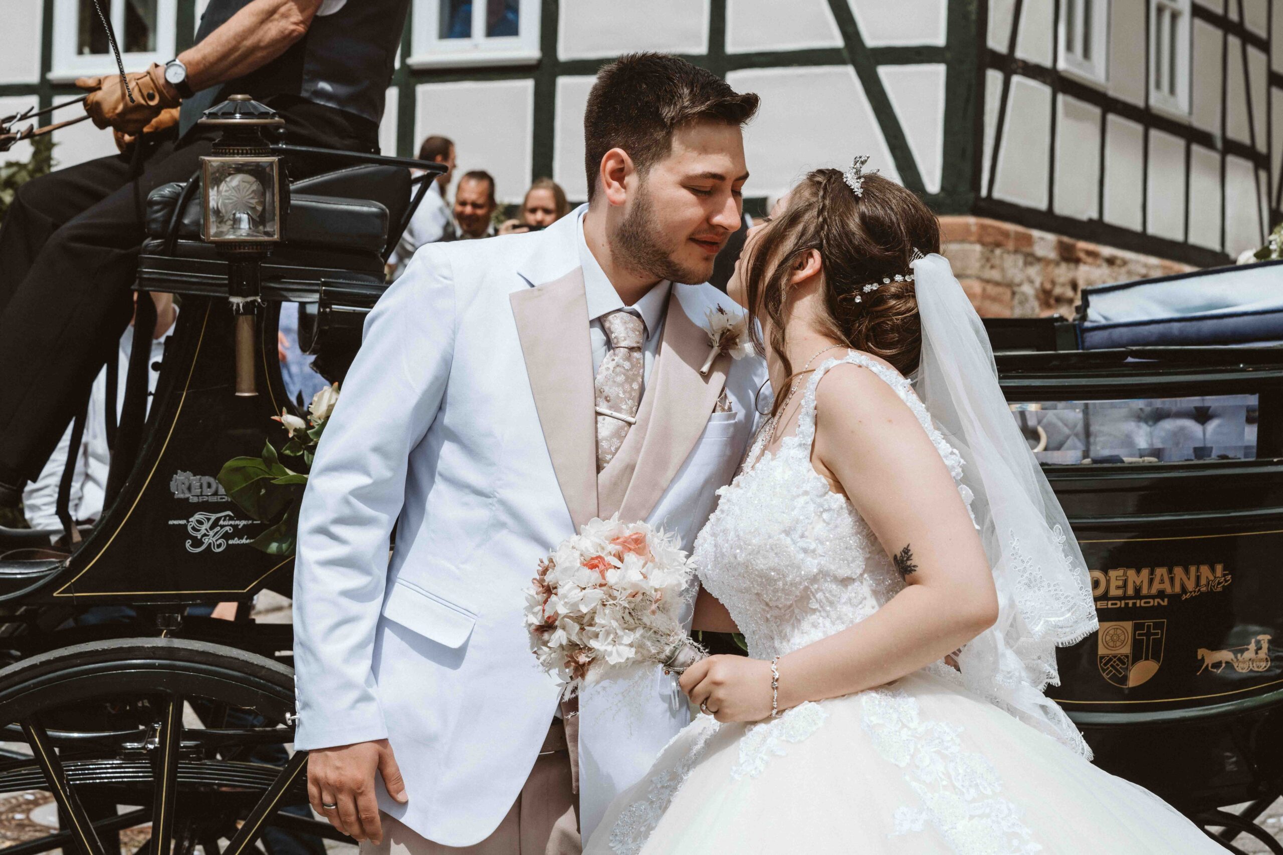 Hochzeitsreportage, küssendes Brautpaar vor Hochzeitskutsche