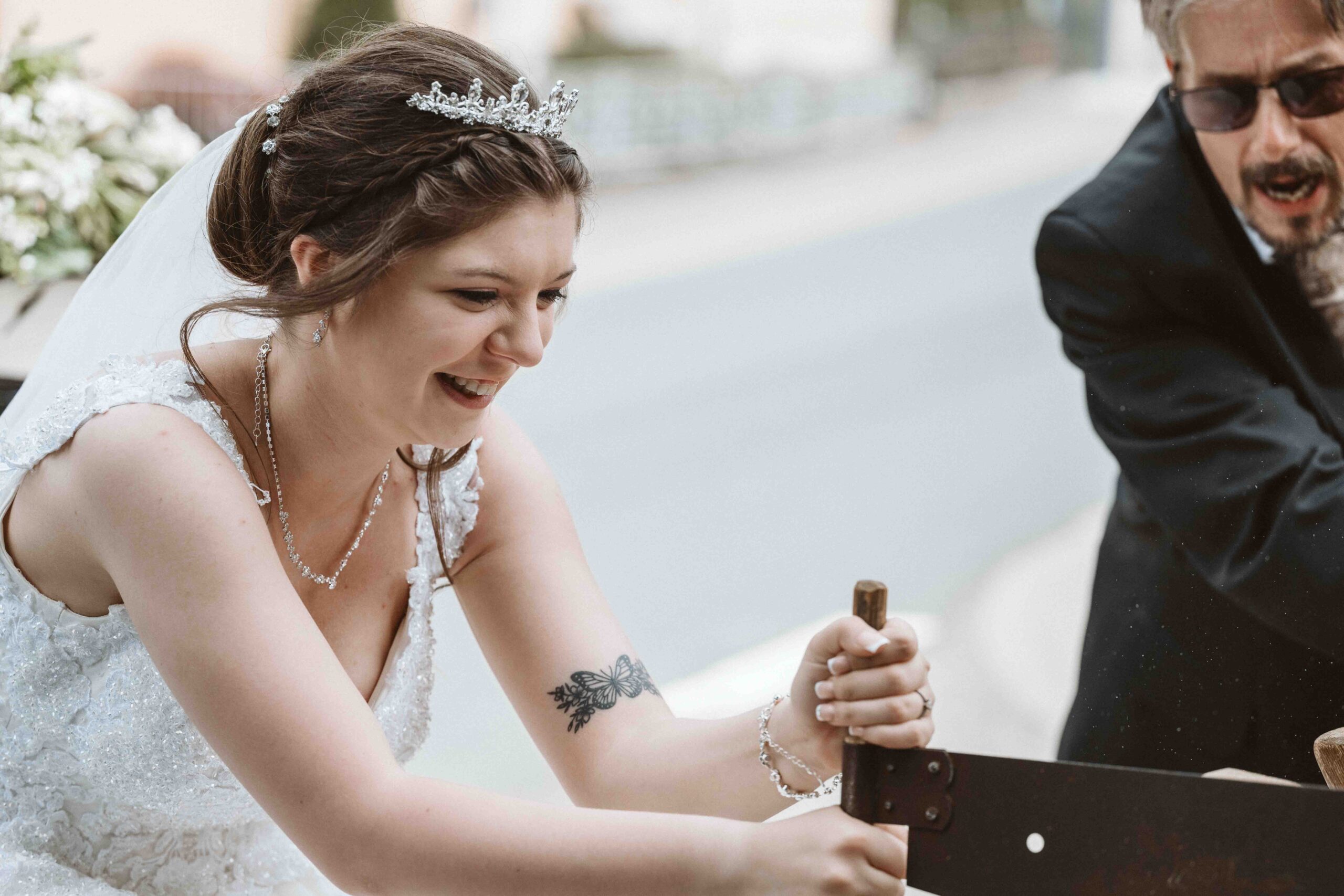 Hochzeitsfotografie, die Braut beim durchsägen eines Baumstamm