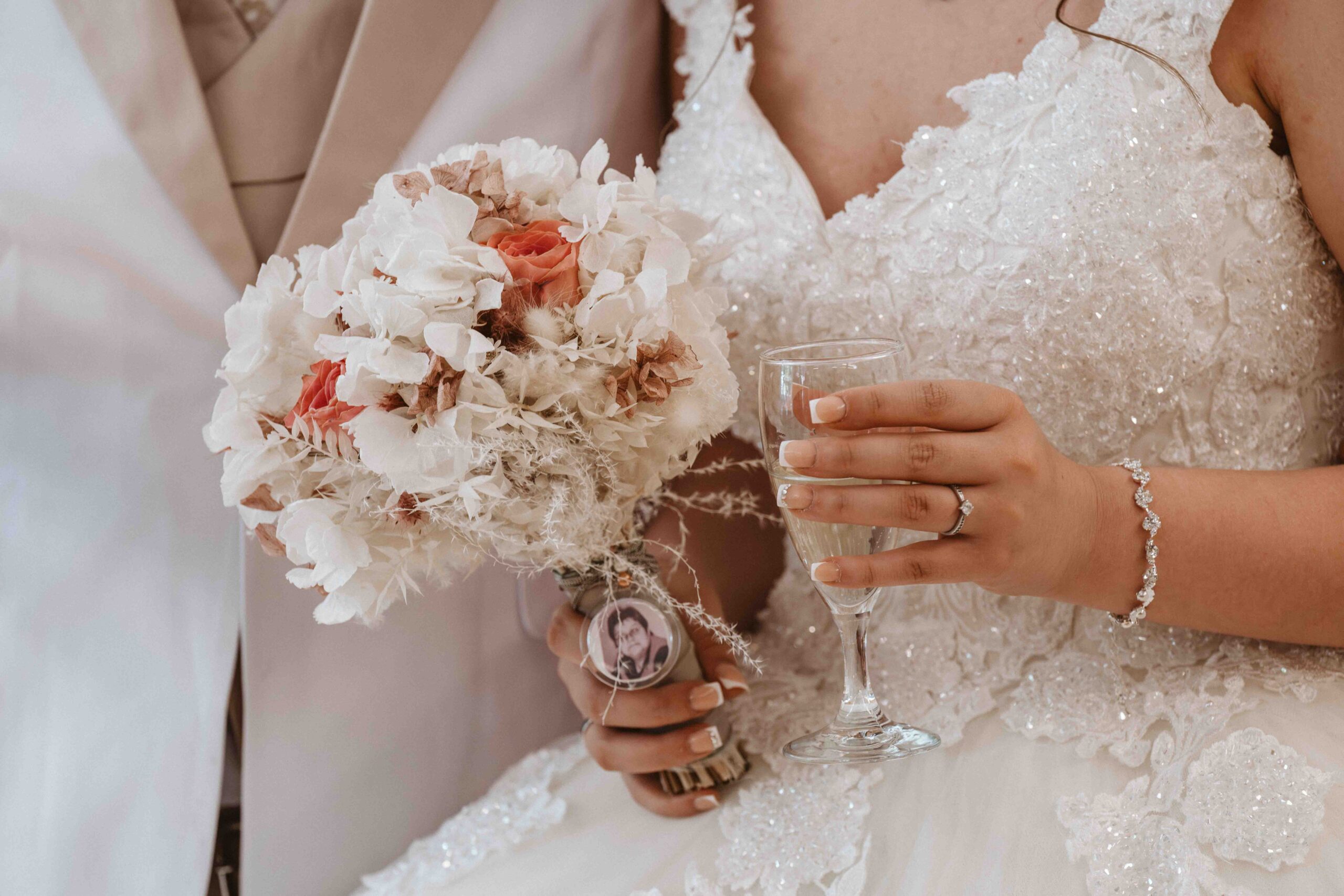 Detailaufnahme des Brautstrauß und ein Glas Sekt