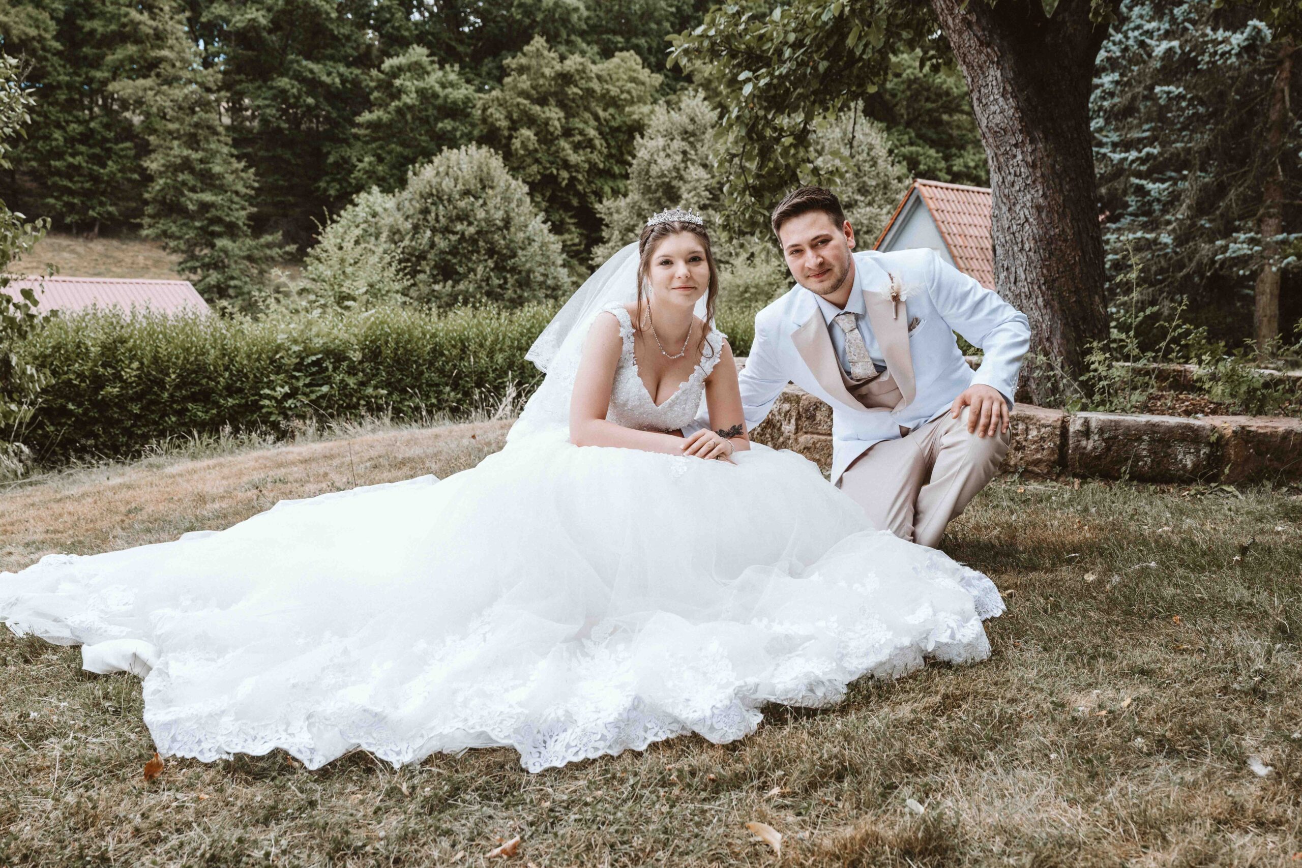 Hochzeitsfoto Brautpaar im weißen Prinzessinnen- Brautkleid und weissen Anzug