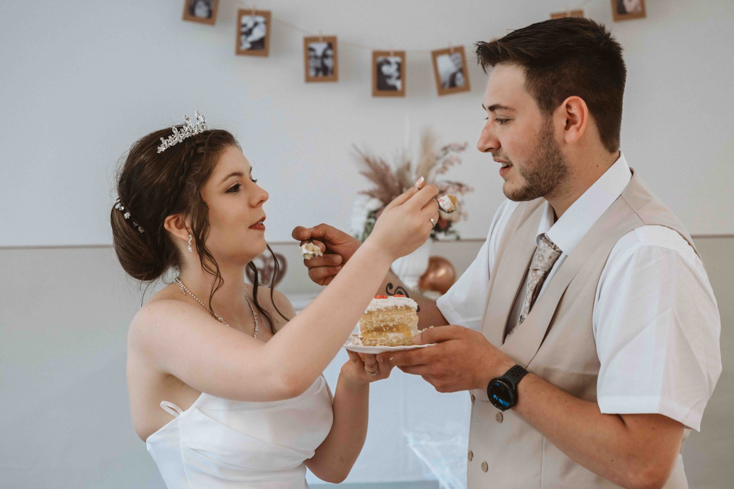 Hochzeitsreportage, Braut und Bräutigam reichen sich gegenseitig eine Gabel mit Hochzeitstorte