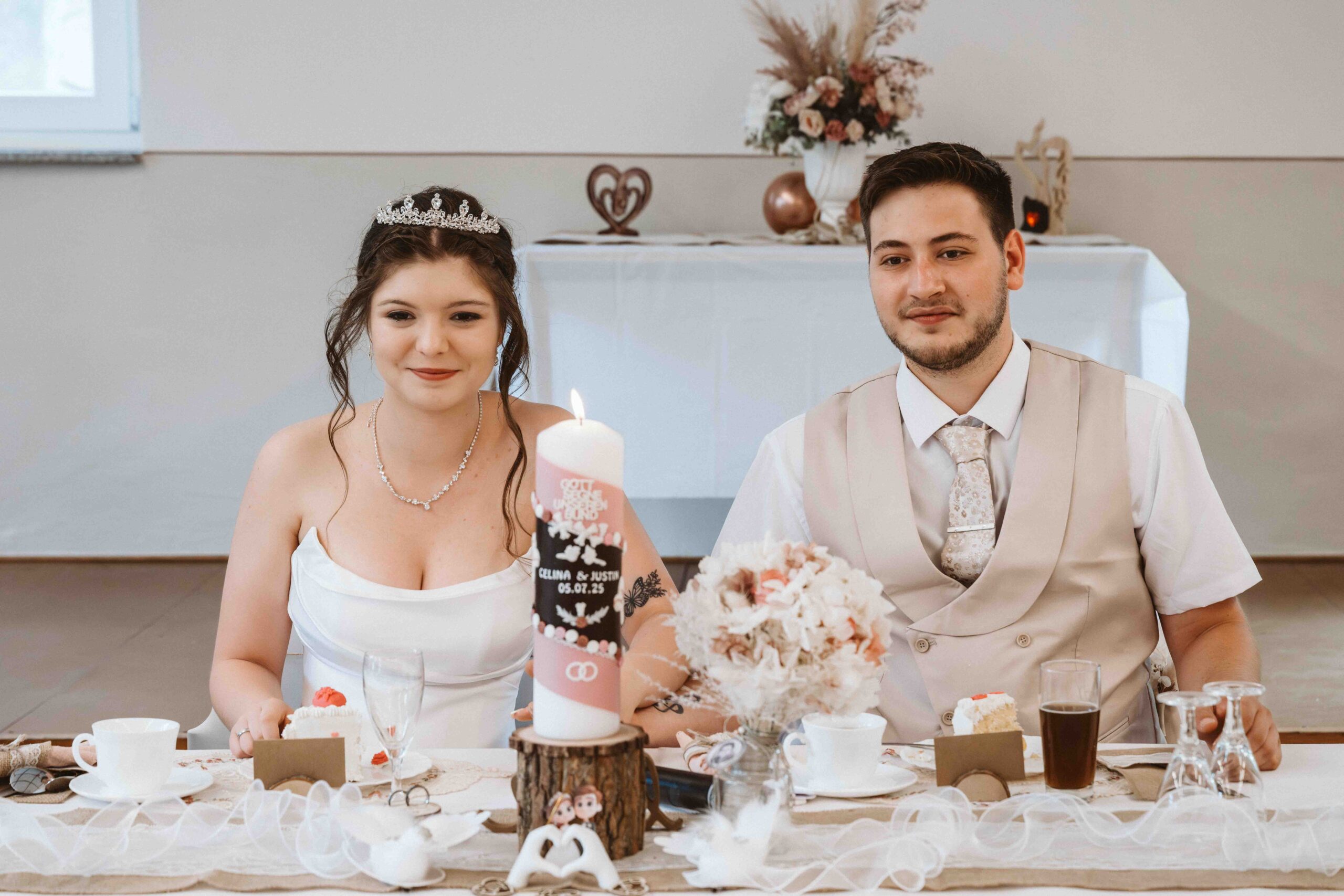 Hochzeitsreportage, Braut und Bräutigam sitzen glücklich an ihren Platz mit der Trauungskerze