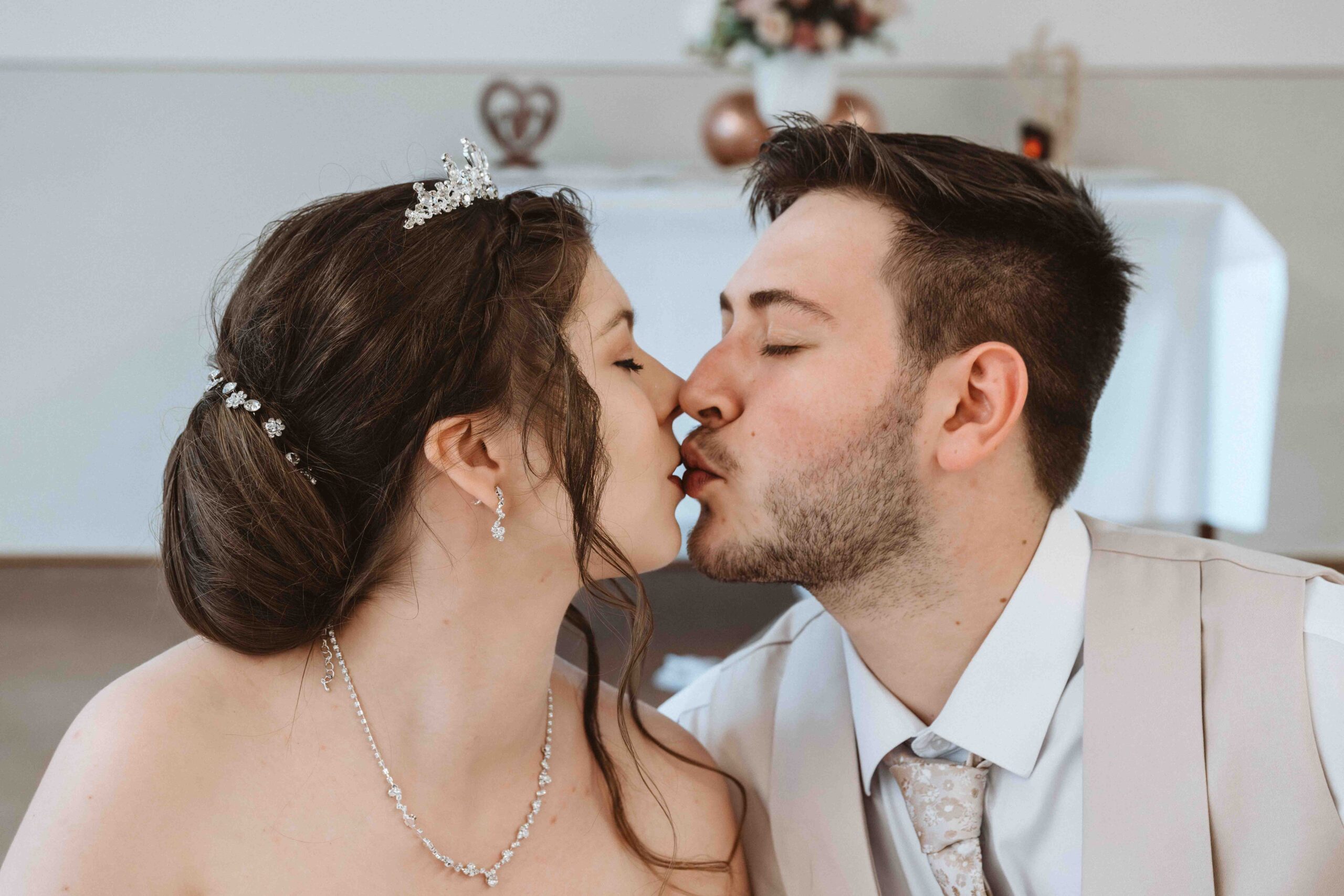 Das Brautpaar küsst sich auf seiner Hochzeitsfeier