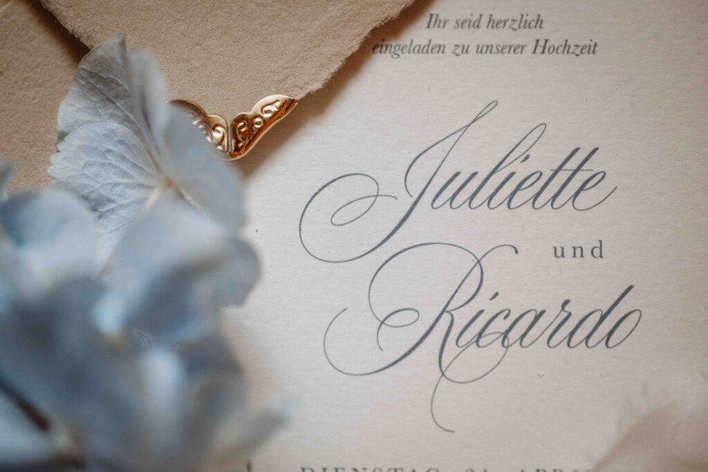 Nahaufnahme einer eleganten Hochzeitspapeterie mit Briefumschlag und goldener Ecke während eines Editorial Styled Shootings.