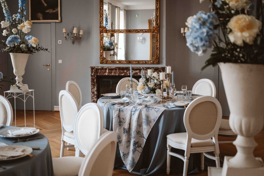 Stilvoll dekorierter Hochzeitstisch mit floralen Arrangements, Spiegel und eleganter Tischdekoration im historischen Ambiente von Schloss Burg Heimerzheim.