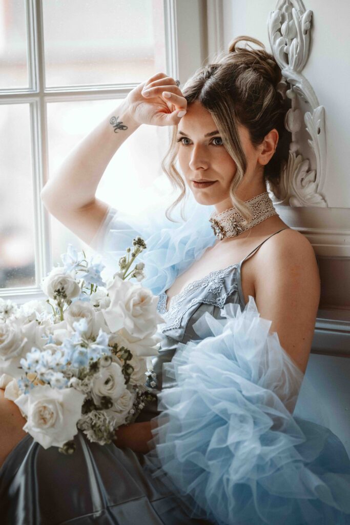 Nahaufnahme einer Braut im Morgenmantel in einem tiefen Fenster auf Schloss Burg Heimerzheim mit seitlicher Ansicht von Kopf und Schulter während eines Bridal Boudoir Shootings.