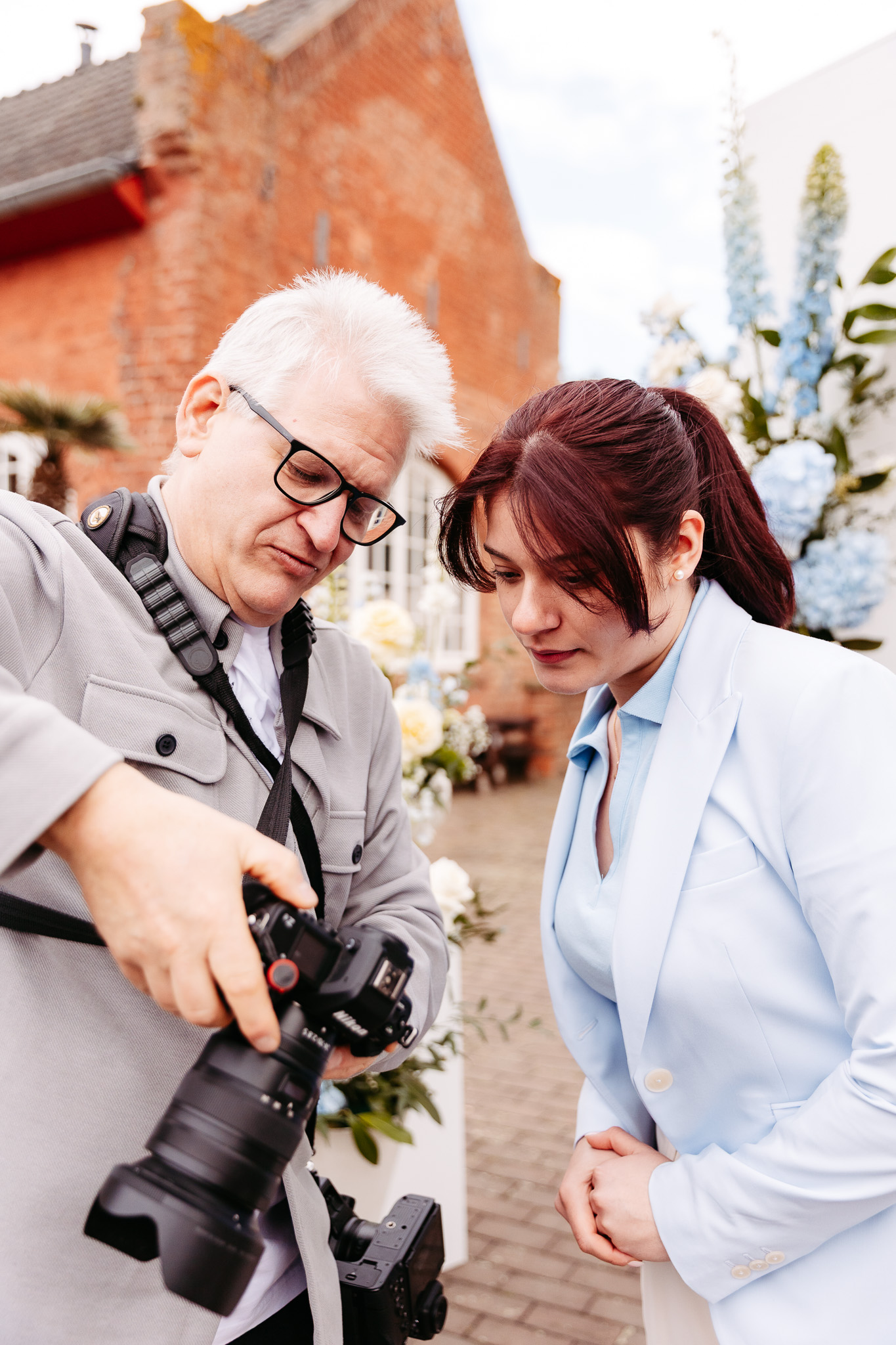 Hochzeitsfotograf Axel Jahnke zeigt einer Hochzeitsplanerin die Aufnahmen auf seiner Kamera und bespricht Details einer Hochzeitsreportage.