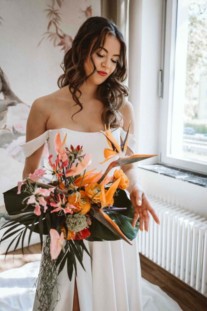 Braut hält ihren farbenfrohen Brautstrauß während des Gettings Ready kurz vor der Hochzeit.