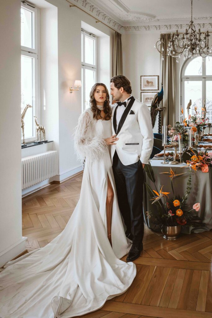 Braut und Bräutigam während eines stilvollen Paarshootings im historischen Festsaal der Villa Bodinus mit festlich dekorierter Hochzeitstafel.