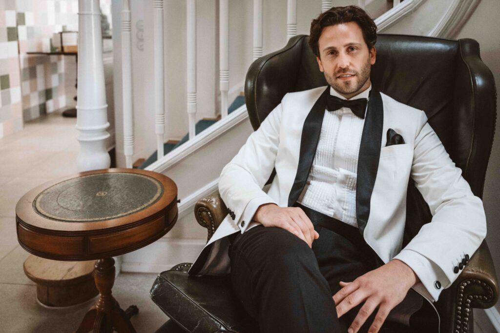 Elegantes Portrait des Bräutigams im weißen Smoking während des Styled Shootings in der Villa Bodinus.