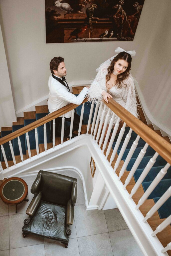 Braut und Bräutigam blicken gemeinsam von der Treppe der Villa Bodinus zur Kamera.